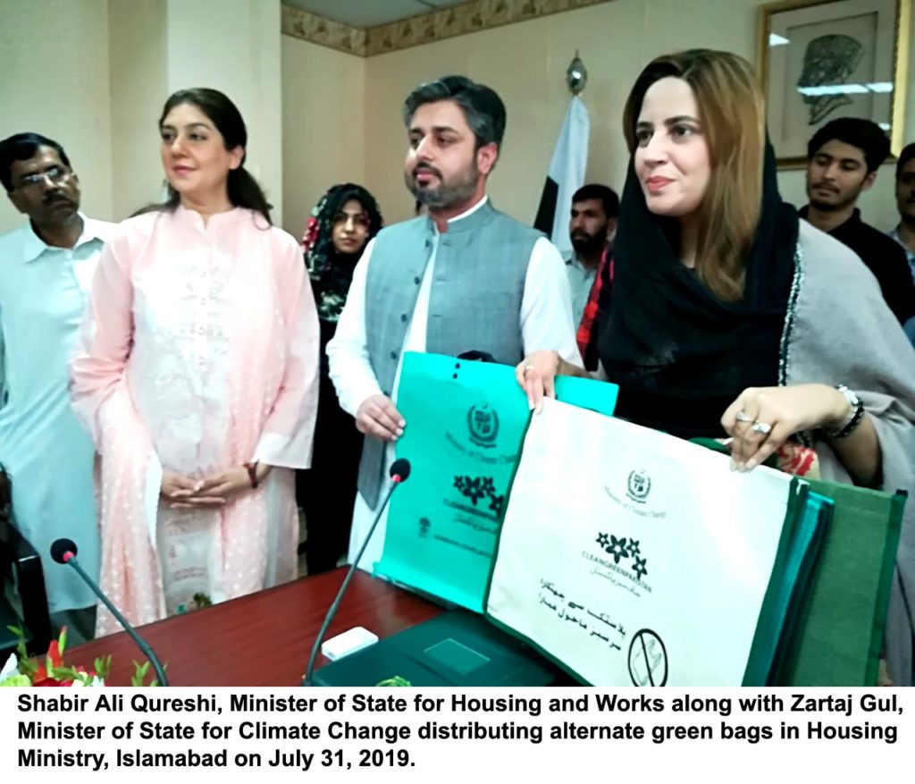 Shabir Ali Qureshi, Minister of State for Housing and Works along with Zartaj Gul, Minister of State for Climate Change distributing alternate green bags in Housing Ministry, Islamabad on July 31, 2019.
